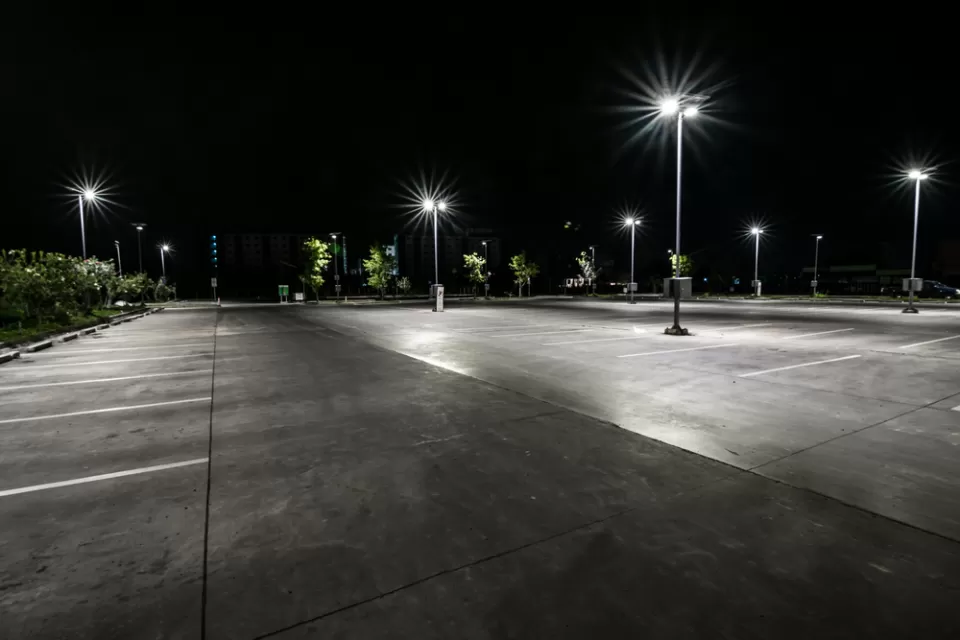 Asphalt parking lot at night with bright lights